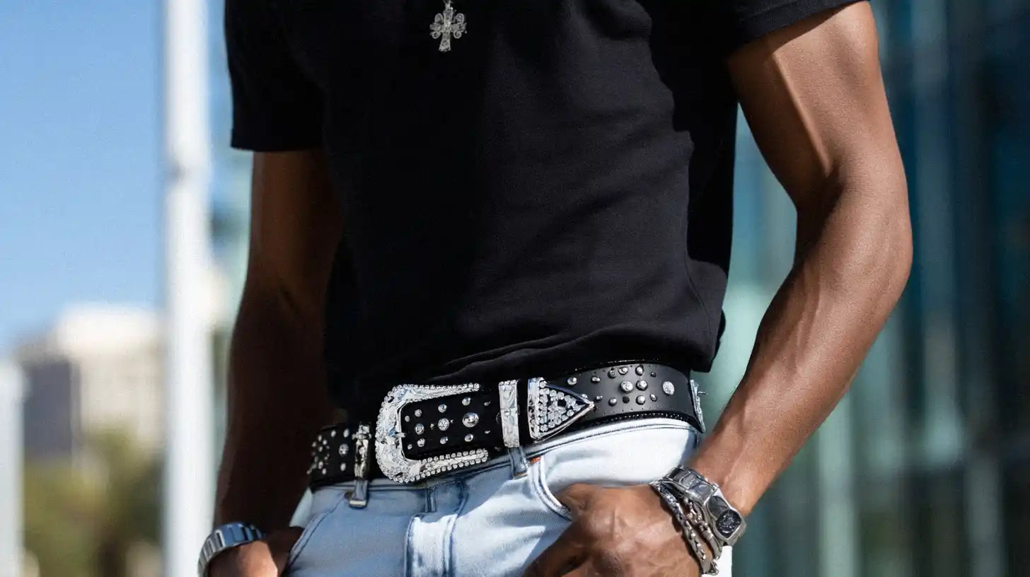 A person in a black t-shirt and light blue jeans is styled with a black rhinestone belt.