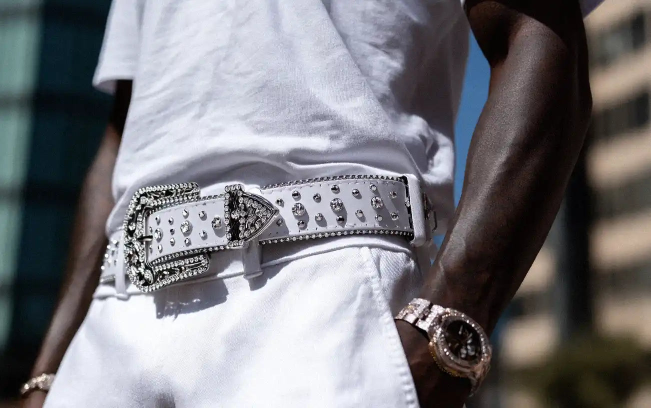 A person in a white t-shirt and white pants is highlighted by a white rhinestone belt.