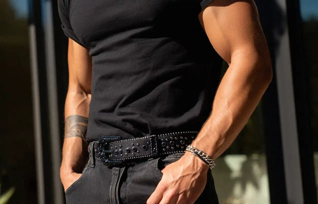 A person in a black t-shirt and black jeans features a black rhinestone belt.