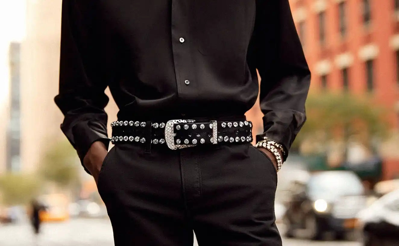A person in a black shirt and black pants showcases a black rhinestone belt.