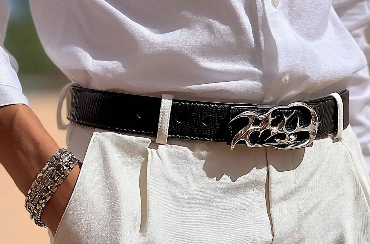 Sleek black y2k belt with chrome flame buckle, styled with white trousers and a button-up shirt.