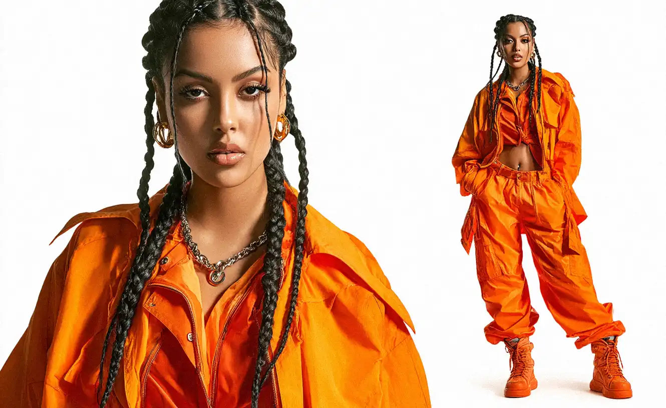 Woman wearing a bright orange oversized set with braided hair and chunky boots, representing bold Y2K fashion inspired by early 2000s streetwear aesthetics.
